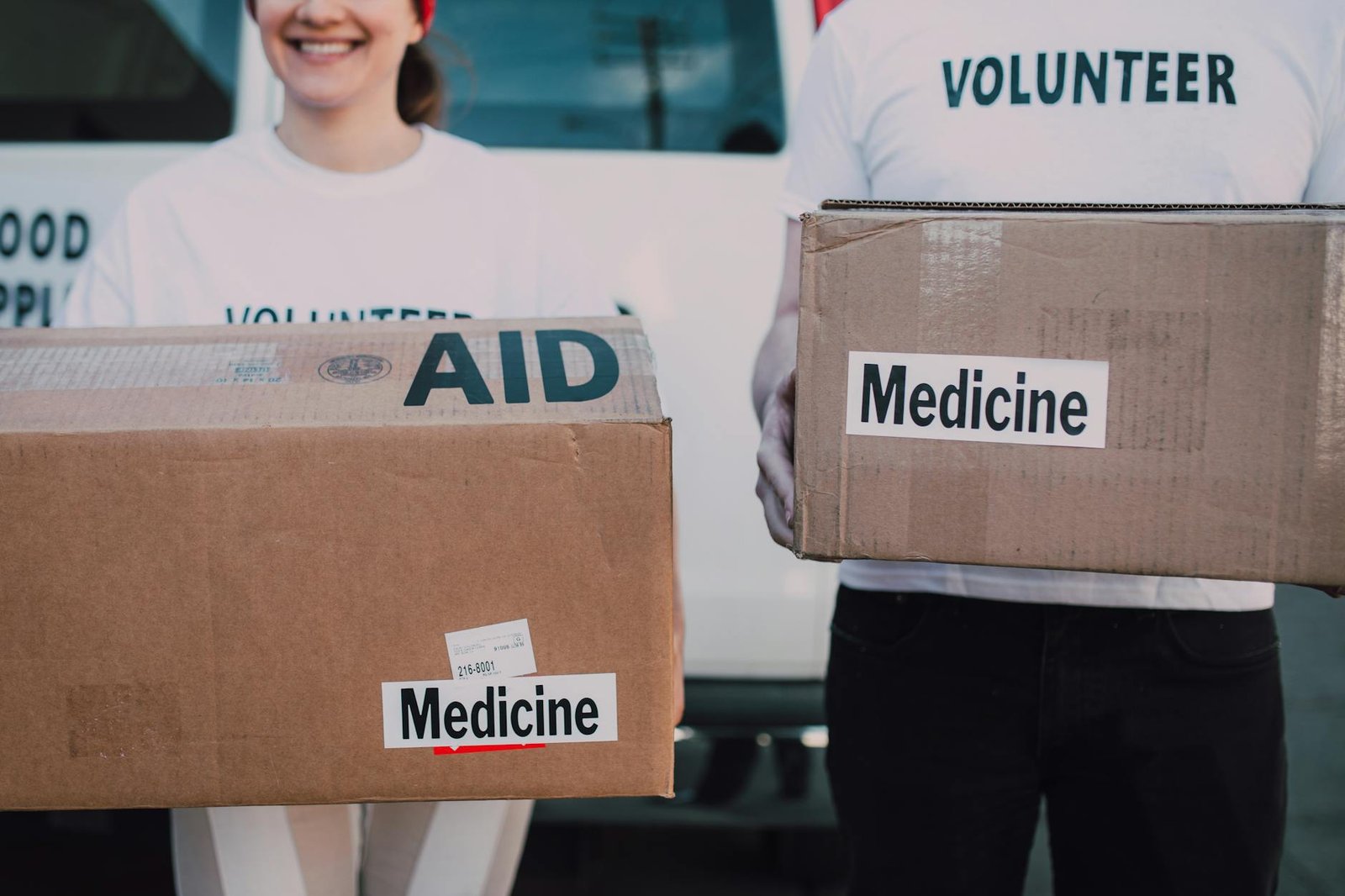 Volunteers preparing aid boxes labelled Medicine