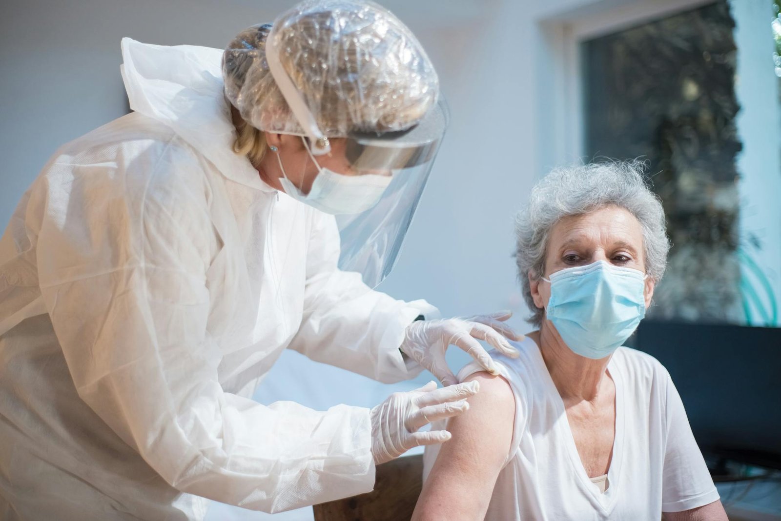 Nurse giving vaccine to senior citizen